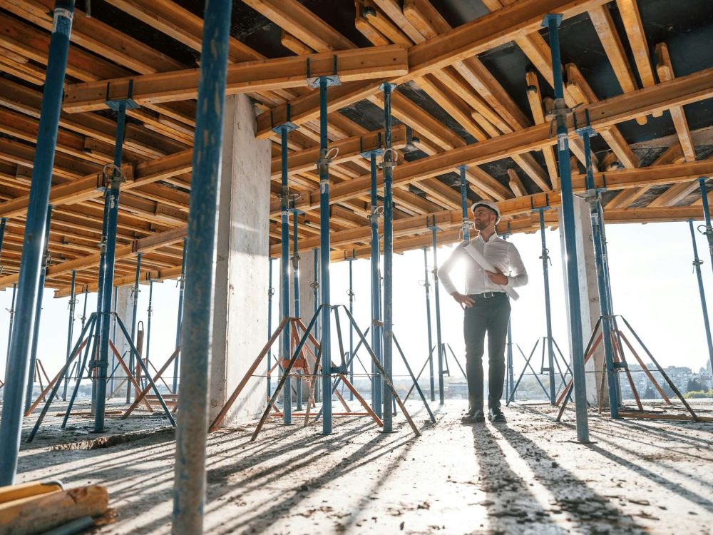 Beautiful sunlight. Walking with plan in hands. Man is working on the construction site at daytime